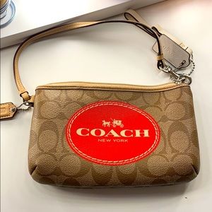 Coach large wristlet tan with burnt orange logo.